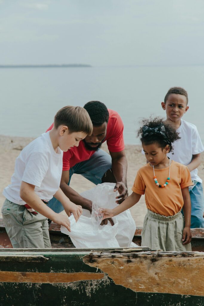 Kids putting trash in a bag at the beach